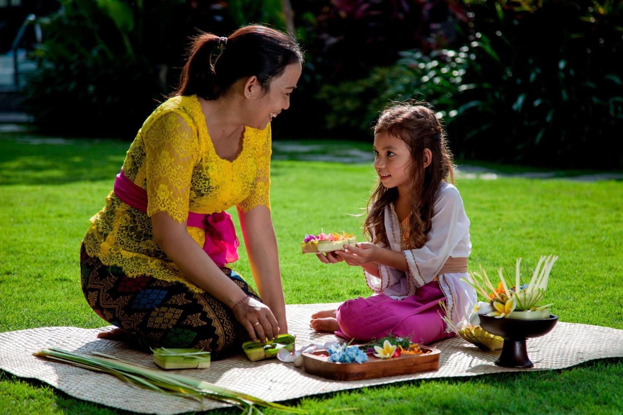 Courtyard By Marriott Bali Seminyak Resort Экстерьер фото A Balinese Hindu woman and her daughter preparing offerings.